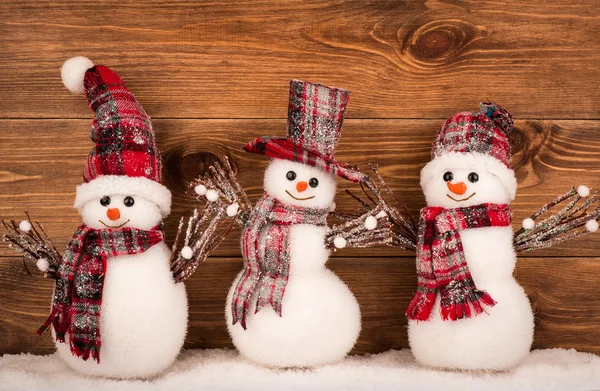 Kerst decoratieve sneeuwpop op de bruin houten achtergrond. — Stockfoto