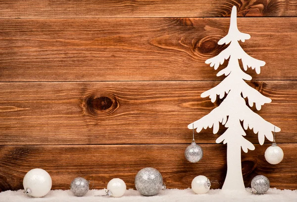 Árvore de Natal branco decorativo com bolas de prata e branco no fundo de madeira . — Fotografia de Stock