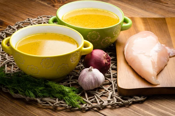 Chicken bouillon in the bowls on the rustic wooden background. — Stock Photo, Image