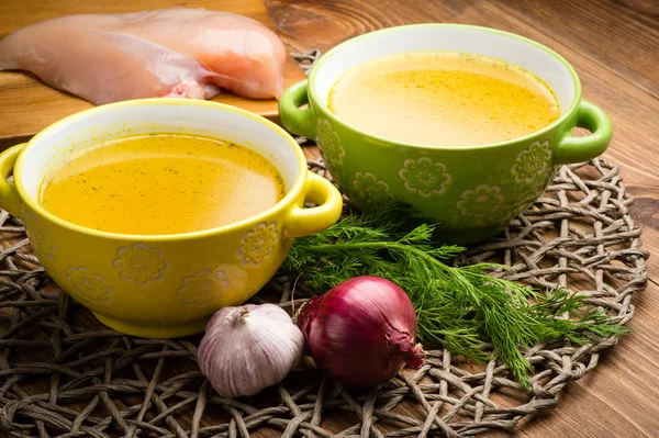 Tavuk bouillon rustik ahşap arka plan üzerinde kase.