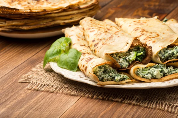 Pancakes filled  with spinach and cheese  on the wooden surface. — Stock Photo, Image