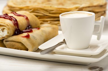 Süzme peynir ve ahşap zemin üzerine kahve dolu krep.