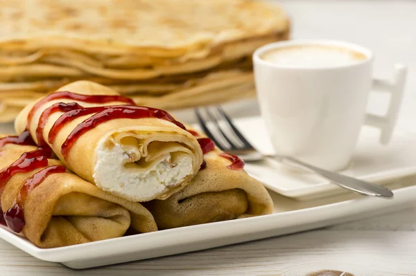 Panquecas cheias de queijo cottage e xícara de café no fundo de madeira . — Fotografia de Stock