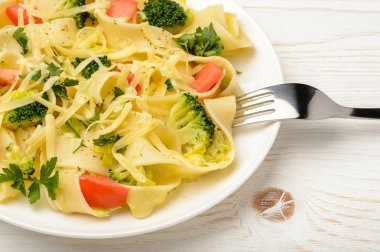 İtalyan makarna brokoli, domates ve peynirle ahşap tablo.