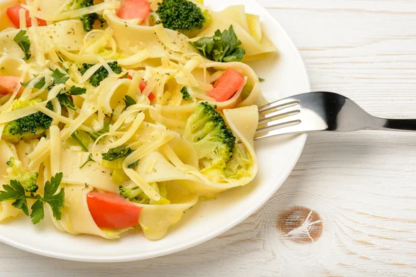 Olasz tészta, brokkoli, paradicsom és sajt, a fából készült asztal. — Stock Fotó