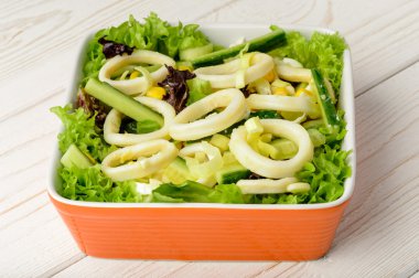 Kalamar halkaları ve ahşap masa sebze salatası.