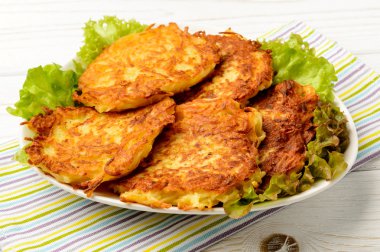 Beyaz ahşap masa üzerinde patates pancakes.