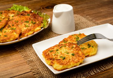 Kahverengi ahşap masa üzerinde patates pancakes.