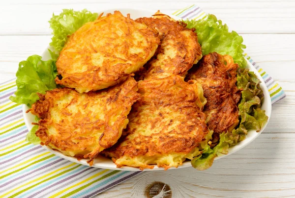 Beyaz ahşap masa üzerinde patates pancakes.