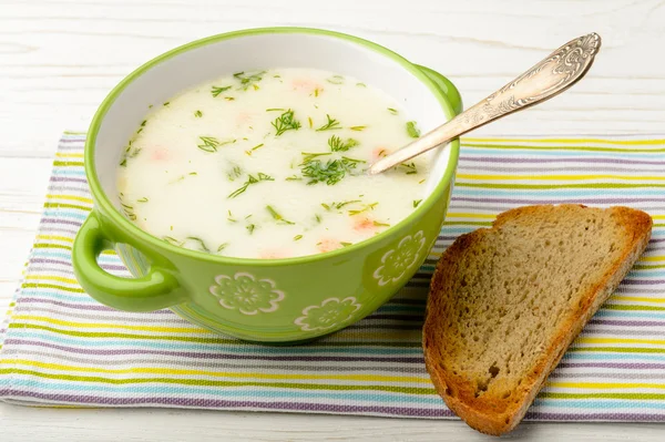 Sopa de queso en tazón verde sobre mesa de madera blanca . —  Fotos de Stock