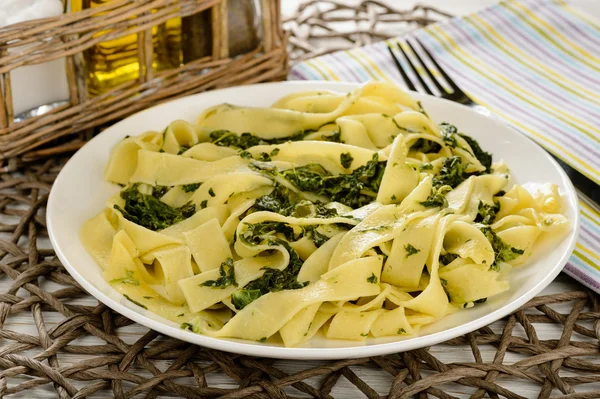 Pasta italiana con spinaci e panna acida sul tavolo di legno . — Foto Stock