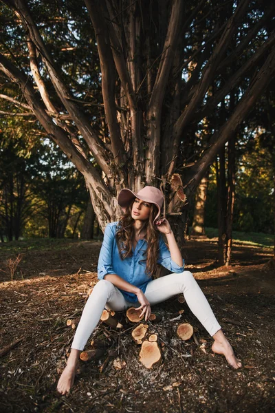 Nő visel kalapot ül az erdő — Stock Fotó