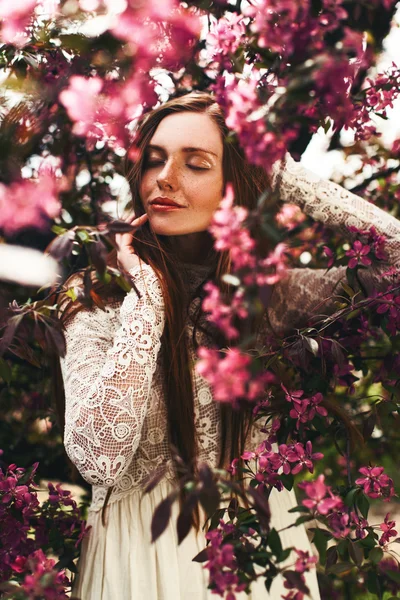 Kvinna med fräknar på ansikte poserar i trädgården — Stockfoto