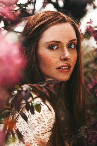 Mulher com sardas no rosto posando no jardim — Fotografia de Stock