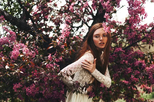 Frau mit Sommersprossen im Gesicht posiert im Garten — Stockfoto