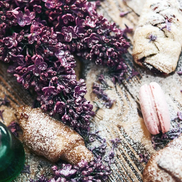 Pastry and macaroon with lilac flowers — Stock Photo, Image