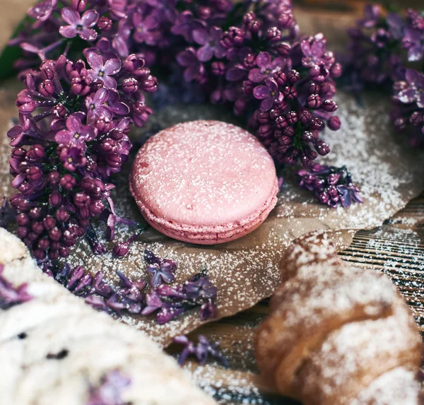 Pastry and macaroon with lilac flowers — Stock Photo, Image