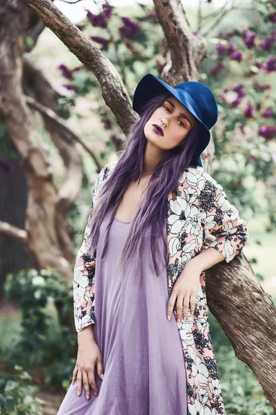 Mulher com cabelo roxo em pé junto à árvore — Fotografia de Stock