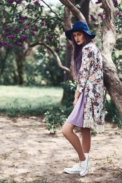 Mulher com cabelo roxo em pé junto à árvore — Fotografia de Stock