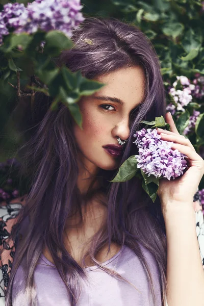 Mulher com cabelo roxo e flores lilás — Fotografia de Stock