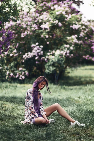 Frau sitzt auf Gras im Park — Stockfoto