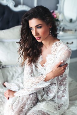 Yatakta oturan şehvetli kadın.