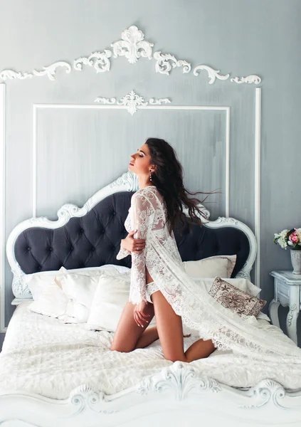 Femme posant sur le lit en lingerie blanche — Photo