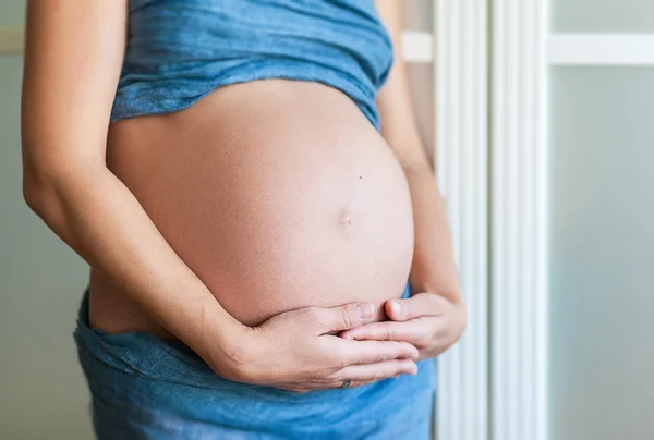 Pregnant woman with hands on belly — Stock Photo, Image