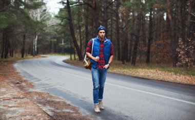 Orman yolu üzerinde yürüyen adam