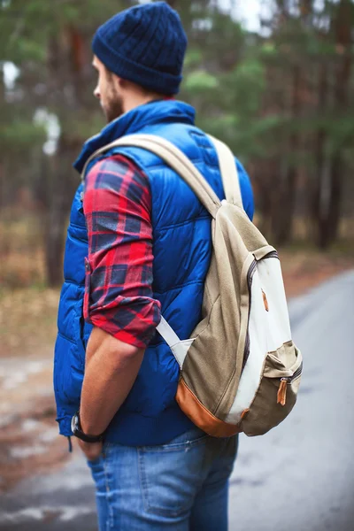 Man standing on road in forest