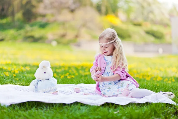 Meisje met thee partij op weide — Stockfoto