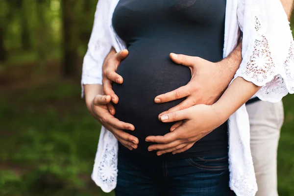 Пара с руками на беременном животе — стоковое фото