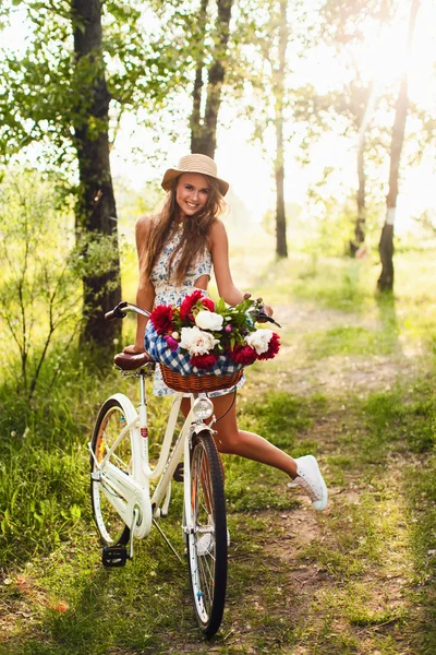 Девушка в парке с винтажным велосипедом — стоковое фото