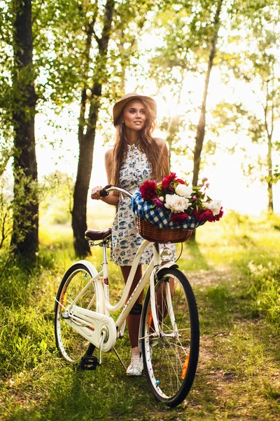 Дівчина в парку з вінтажним велосипедом — стокове фото