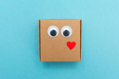 Gözleri ve kalbi olan komik bir el işi kutusu. Sevgililer Günü. Kağıttan yapılmış kare emoji. Aşkın dışavurumu.