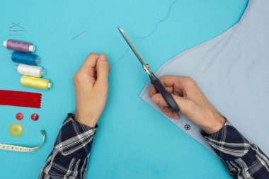 Terzi dikiş diker, ipliği keser. Aksesuar, iğne, düğme, fermuar ve makas dikmek. Reklam pankartı.