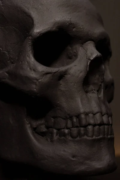 Черный бетонный череп закрывается. Проломлен череп. Черный декор на Хэллоуин. Минимализм в интерьере. Вертикаль. — стоковое фото