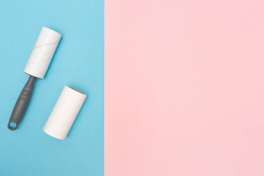 Temizlikçi. Yapışkan iplik paten seti. Mavi ve pembe arka plan. Uzayı kopyala Mesaj için yer. Üst görünüm.