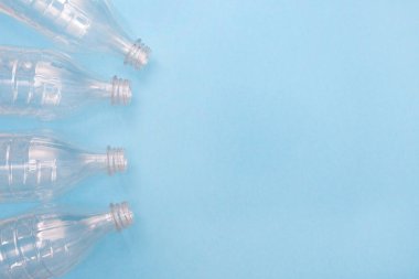 Mavi arka planda plastik şişeler ve mesaj için yer var. Plastik kullanılmasına karşı. Geri dönüşüm. Ekoloji problemi, çevre kirliliği. Boşluğu kopyala.