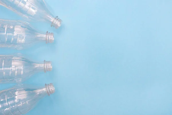 Mavi arka planda plastik şişeler ve mesaj için yer var. Plastik kullanılmasına karşı. Geri dönüşüm. Ekoloji problemi, çevre kirliliği. Boşluğu kopyala.