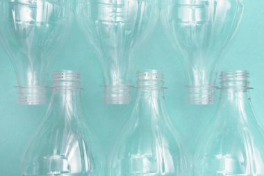 Turkuaz arka planda kullanılmış plastik şişeler. Plastik geri dönüşüm sorunu. Plastik üretim ve işleme konsepti. Düz yatıyordu.