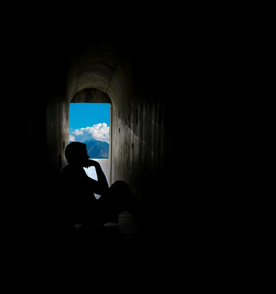 Silhueta de homem sentado no túnel — Fotografia de Stock