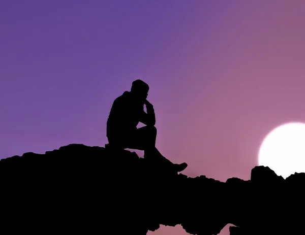Silueta muže, který seděl při západu slunce — Stock fotografie