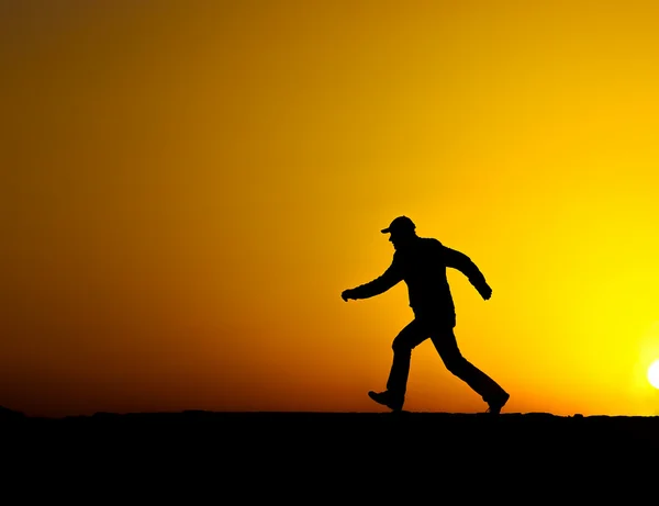 Silueta muže běží při západu slunce — Stock fotografie