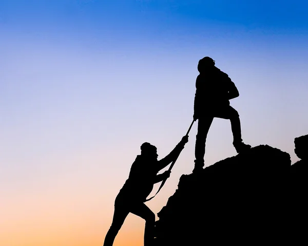 Silhouette di mano di aiuto tra due scalatori — Foto Stock