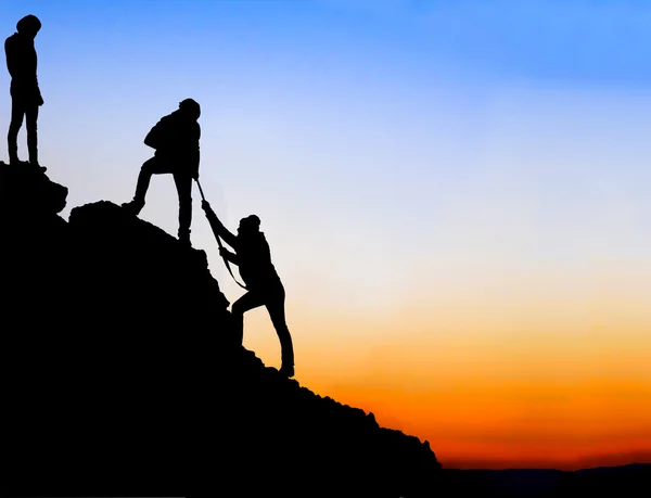 Silhouette der helfenden Hand zwischen zwei Bergsteigern — Stockfoto