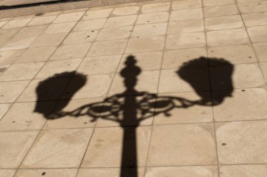 Shadow of a lamppost on the sidewalk in Cadiz, Spain