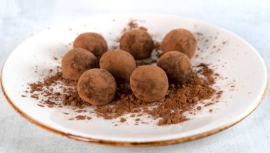 Ev yapımı sağlıklı vejetaryen çikolatalı trüf şekeri ve içinde tatlı krema var. Beyaz tabakta lezzetli mantarlar. Seçici odaklanma. Yan görüş. Yatay yönelim.