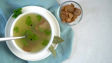 Stir homemade chicken bone broth with parsley, peppercorns and croutons. 