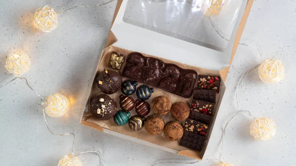 Chocolate candies, chocolate bar 2021and truffles in a present box.